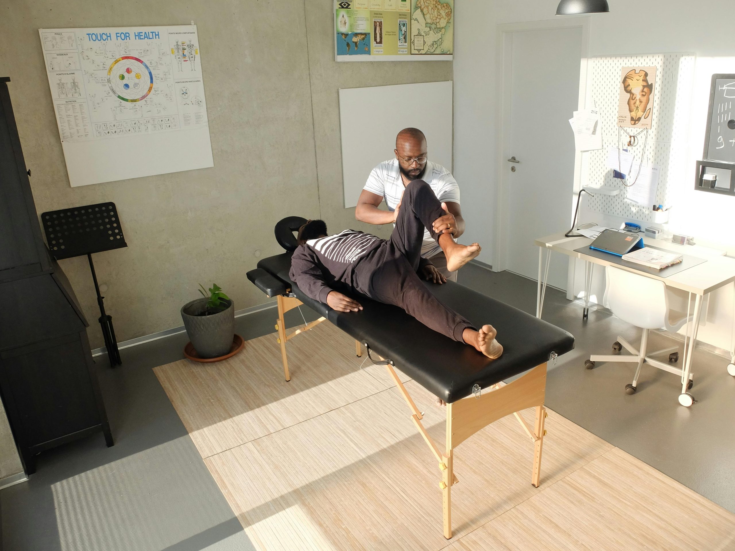 Therapist performing therapeutic massage in a clinic setting, emphasizing wellness and relaxation for sports recovery.
